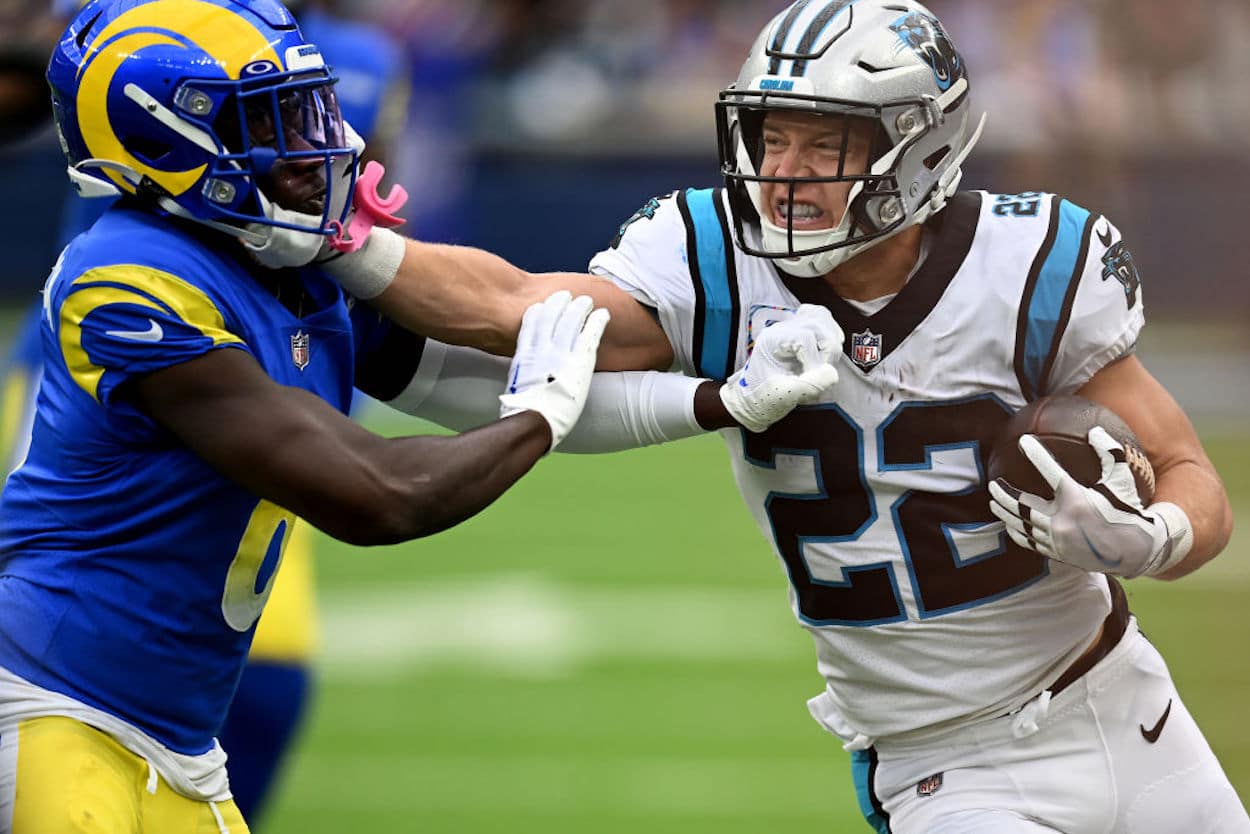 Former Carolina Panthers Running Back Christian McCaffrey stiff-arms a defender.