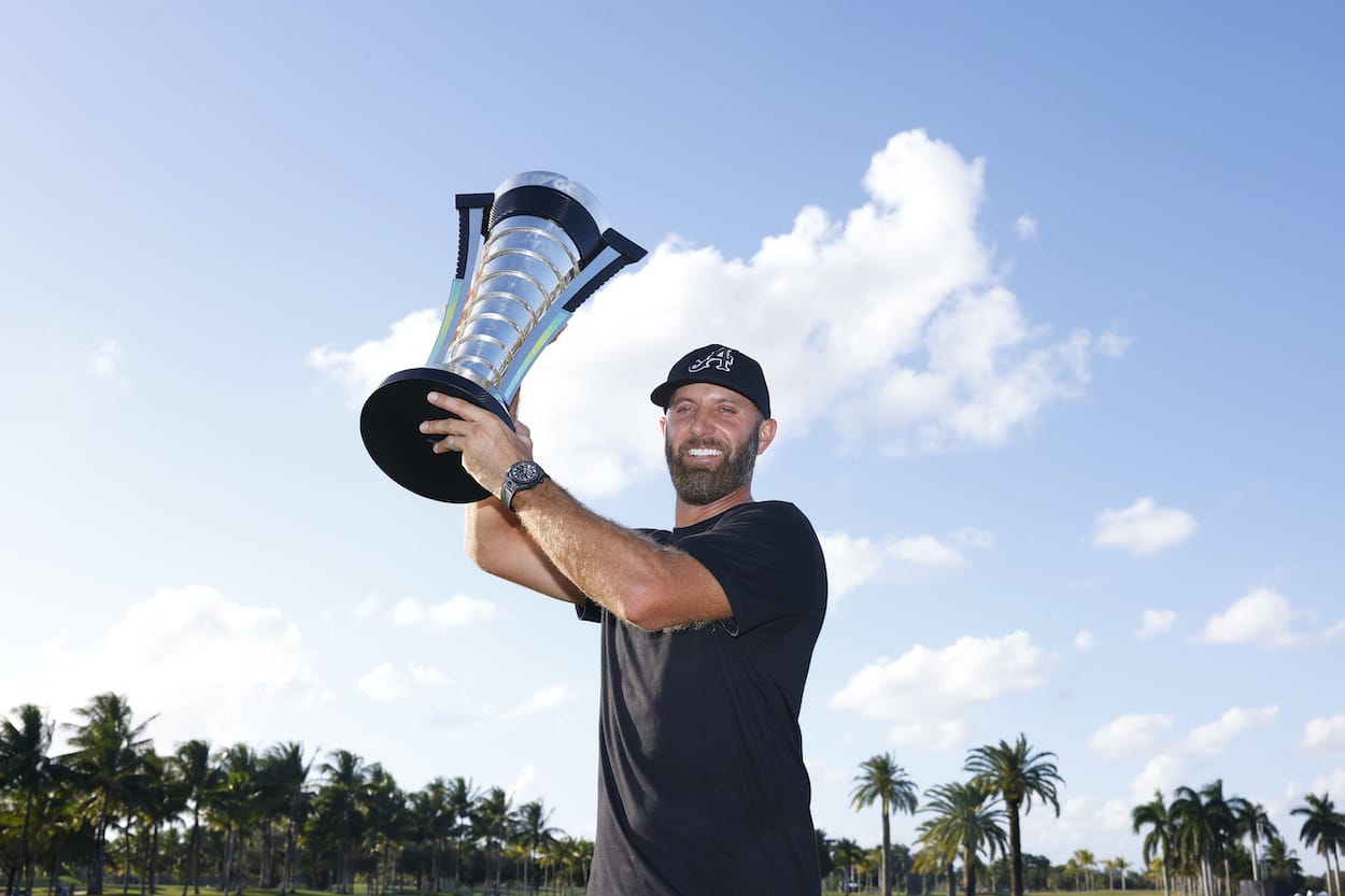 Dustin Johnson celebrates with the LIV Golf trophy.