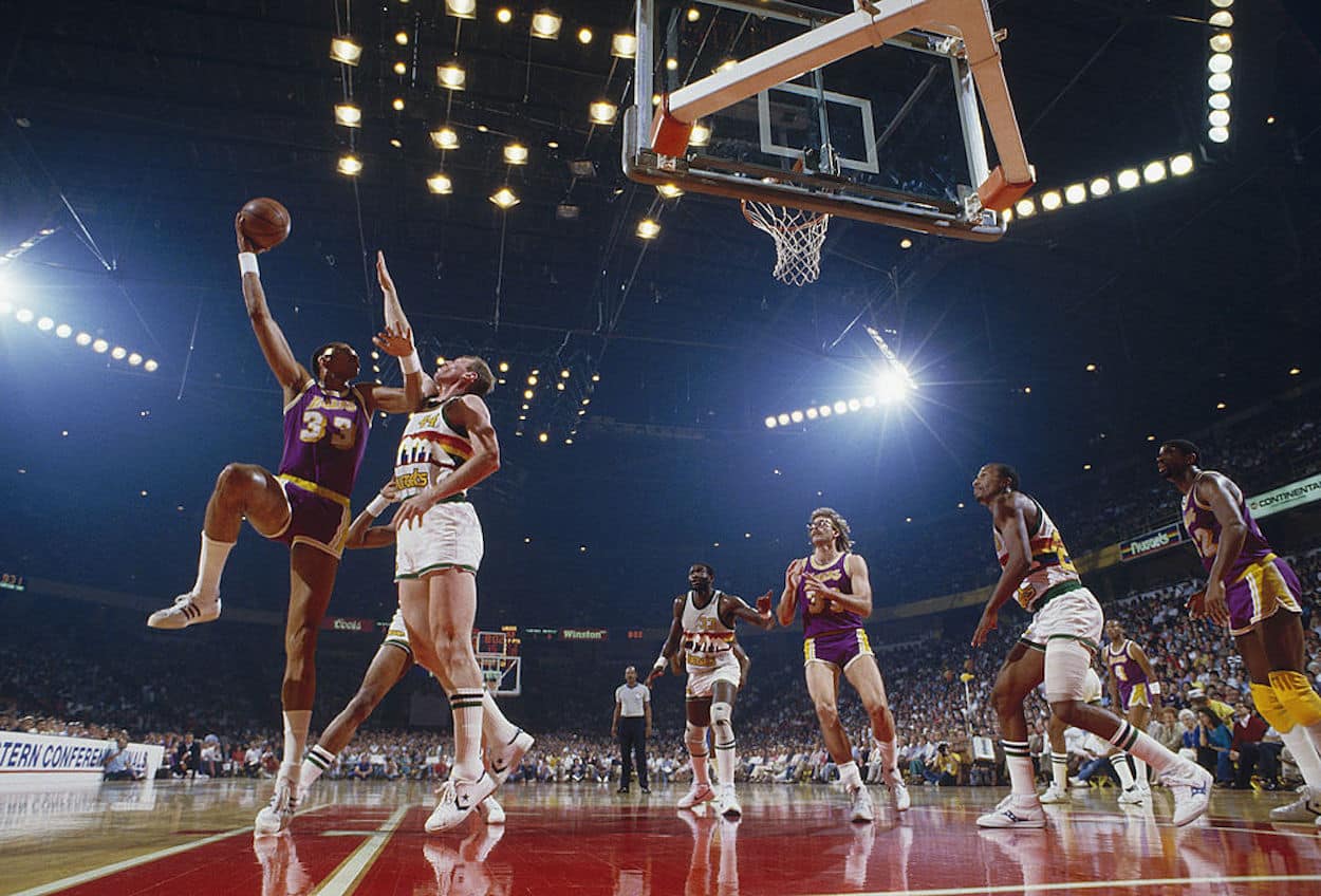 Kareem Abdul-Jabbar (L) attempts a hook shot over a Denver Nuggets defender.