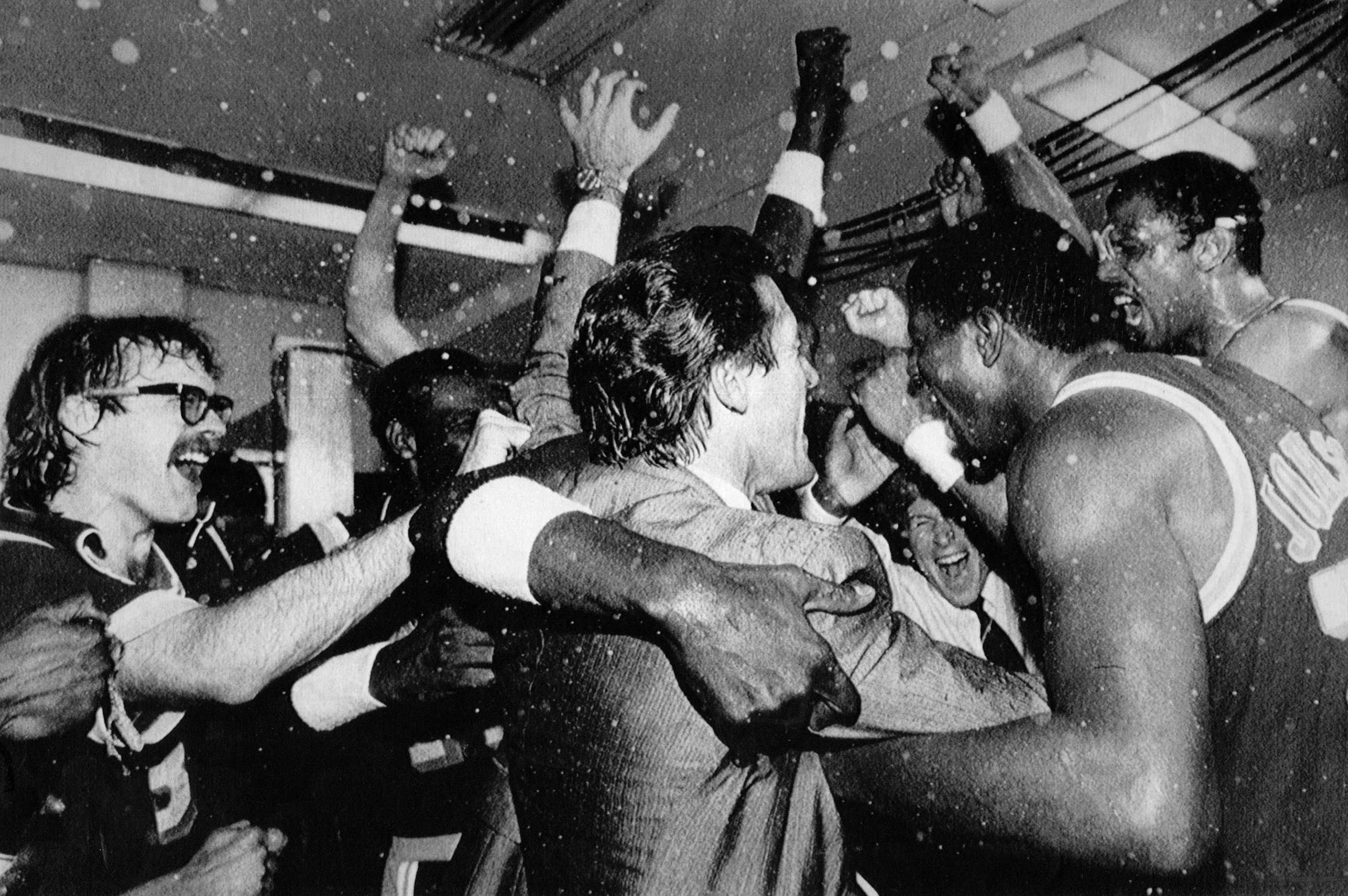 The Lakers' Kurt Rambis, left, Coach Pat Riley, center, and Magic Johnson, right, celebrate with the rest of the team.