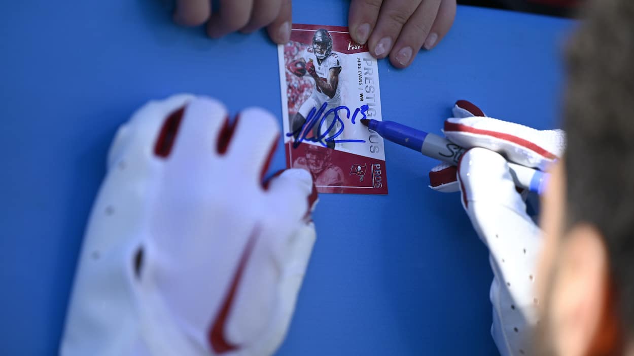 Mike Evans of the Tampa Bay Buccaneers signs an autograph before talking to NFL referees about golf lessons.