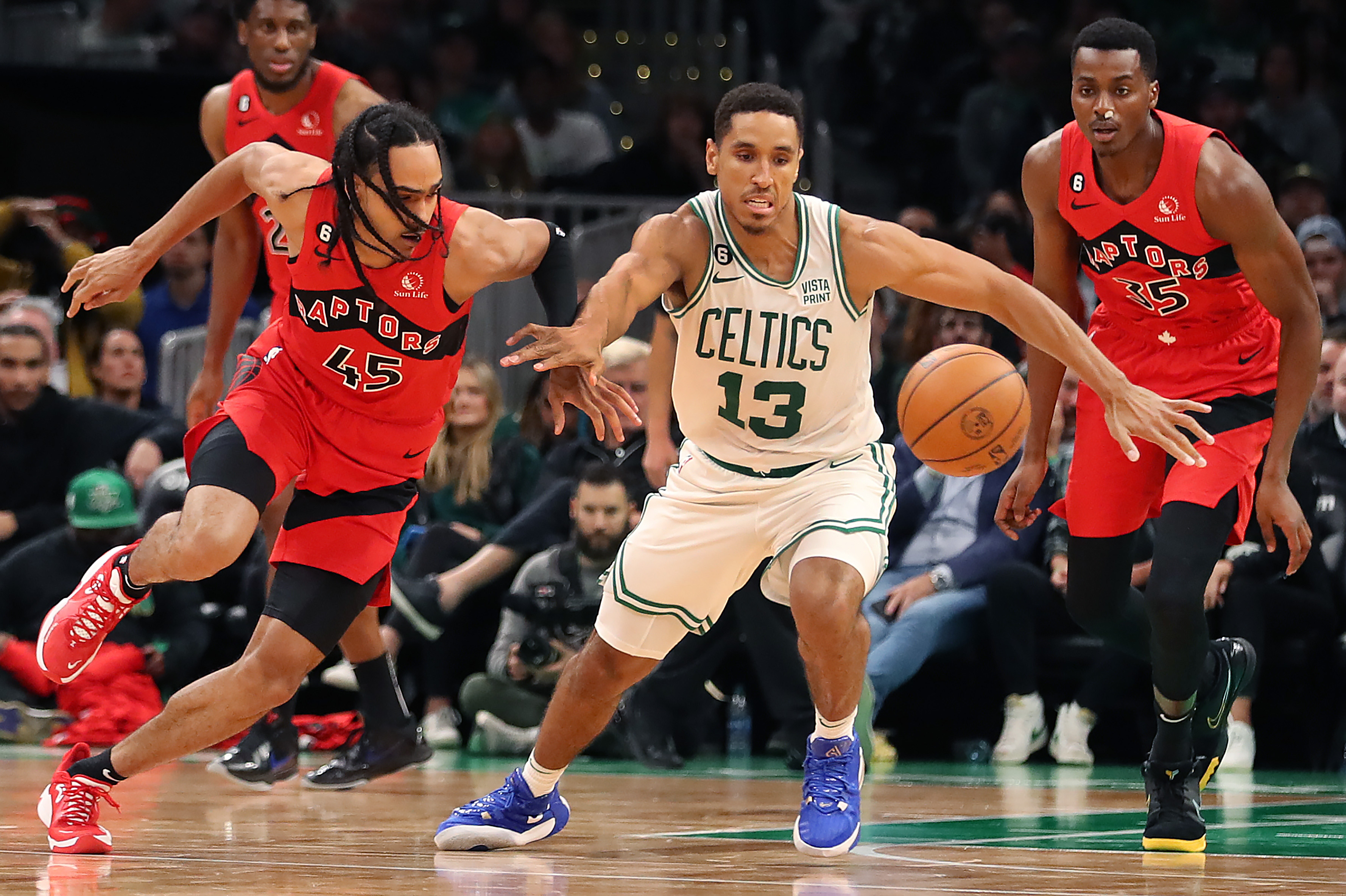 Boston Celtics guard Malcolm Brogdon battles Toronto Raptors guard Dalano Banton for a loose ball.