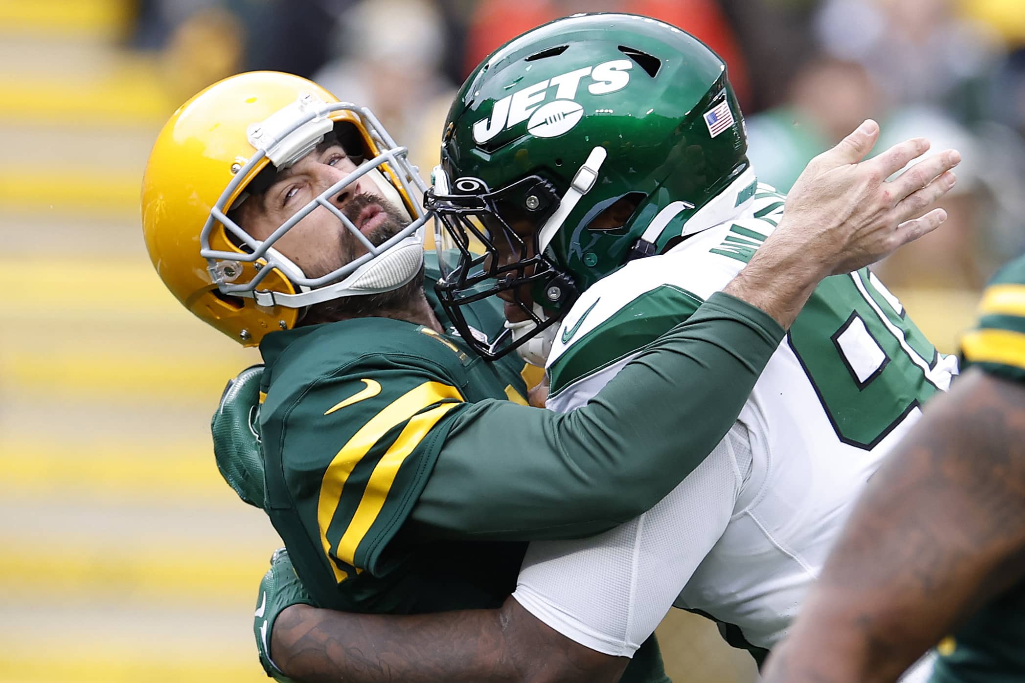 Aaron Rodgers of the Green Bay Packers gets hit while throwing a pass.