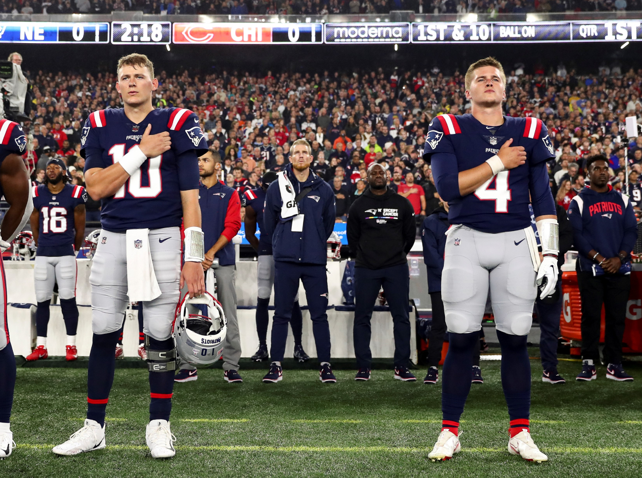 Mac Jones, left, and Bailey Zappe of the New England Patriots stand during the national anthem.