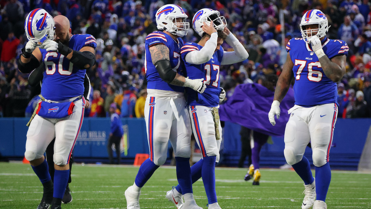 Spencer Brown of the Buffalo Bills holds Josh Allen as Allen reacts after throwing an interception in overtime against the Minnesota Vikings.