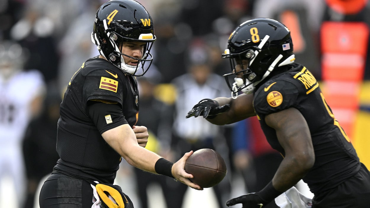 Taylor Heinicke hands off to Brian Robinson Jr. of the Washington Commanders.