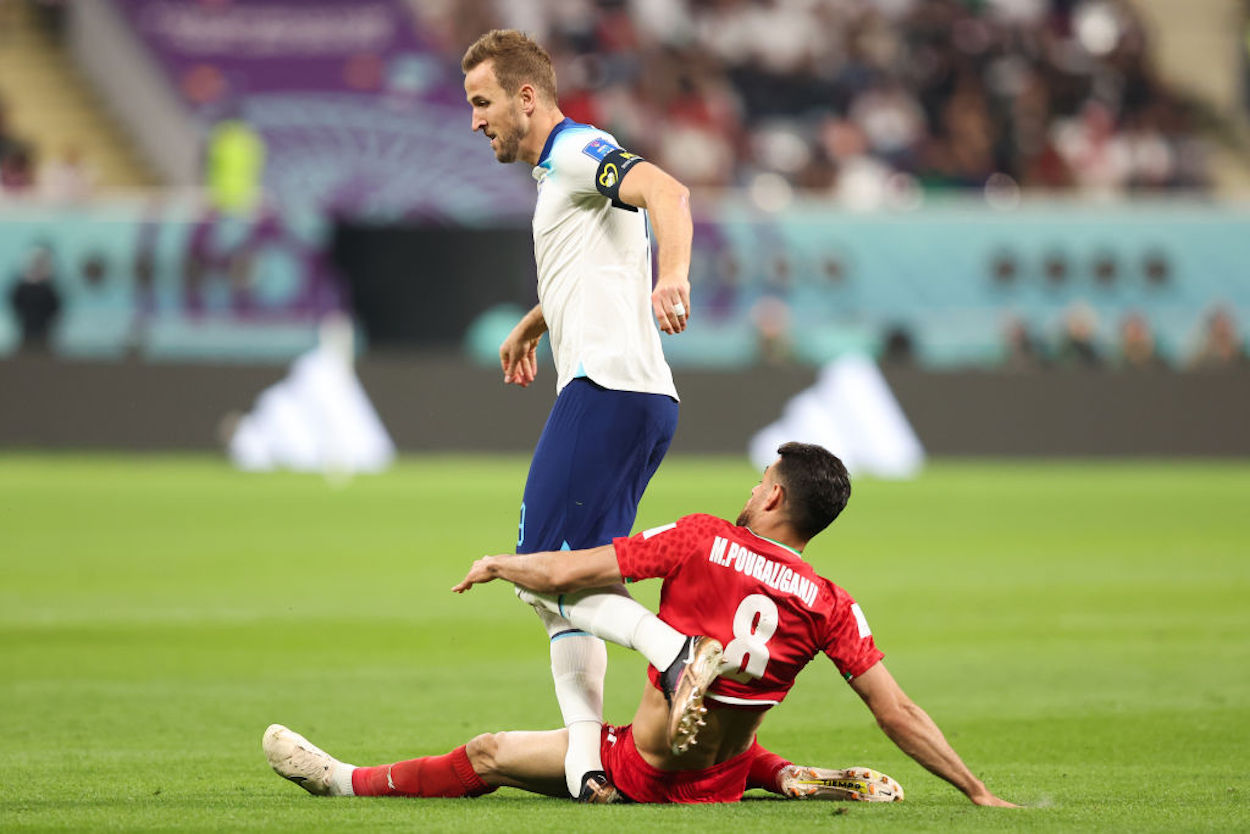 England captain Harry Kane absorbs a tackle from Iran's Morteza Pouraliganji