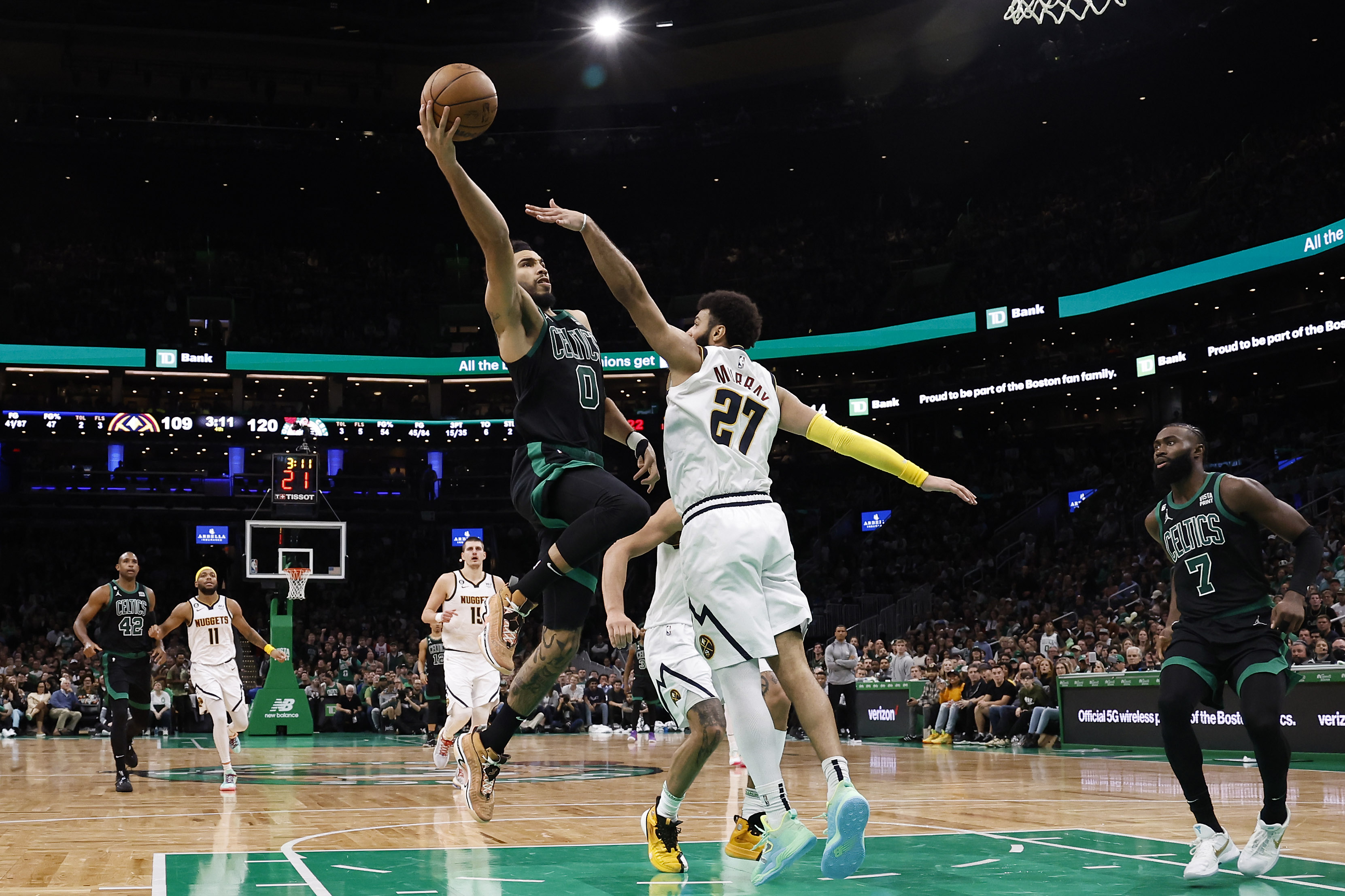 Jayson Tatum of the Boston Celtics goes to the basket against Jamal Murray of the Denver Nuggets.