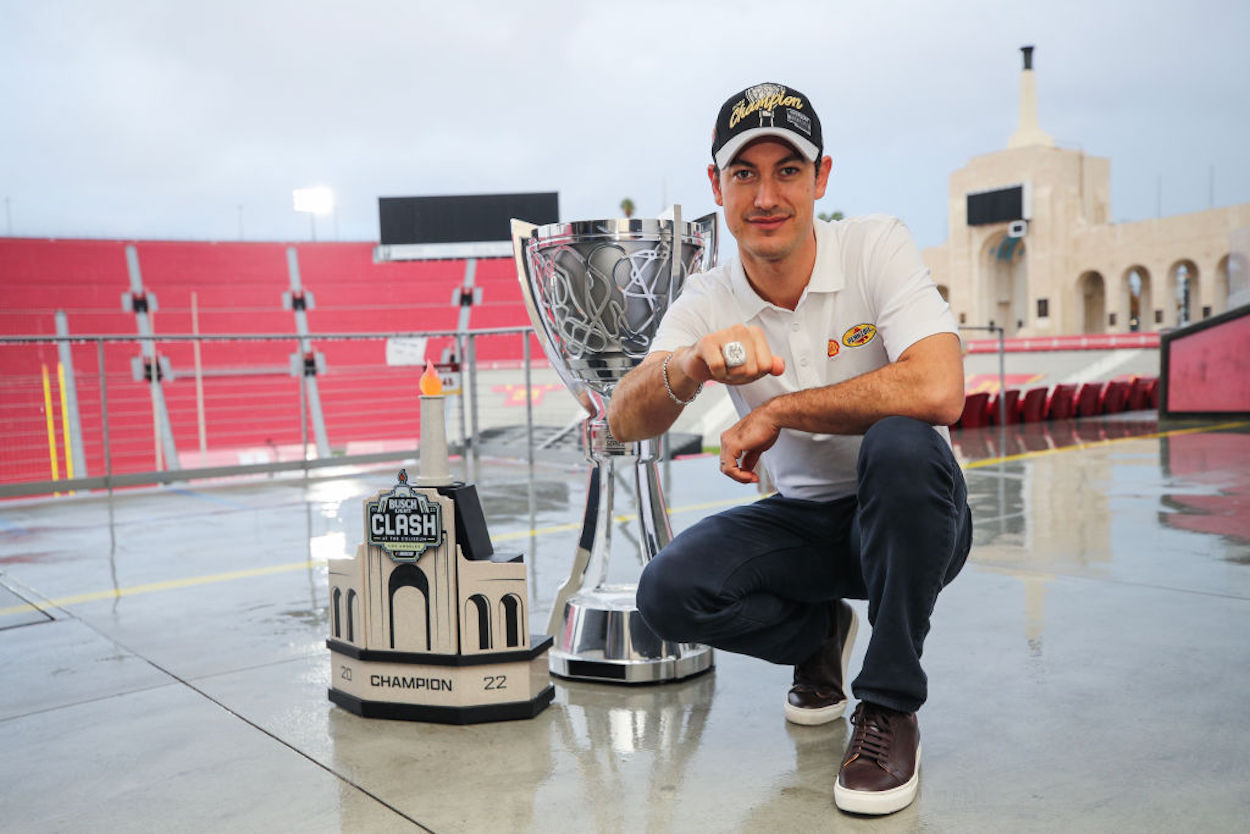 Joey Logano poses with the Bill France NASCAR Cup Series Championship trophy and his NASCAR Clash at the Coliseum trophy at LA Memorial Coliseum.