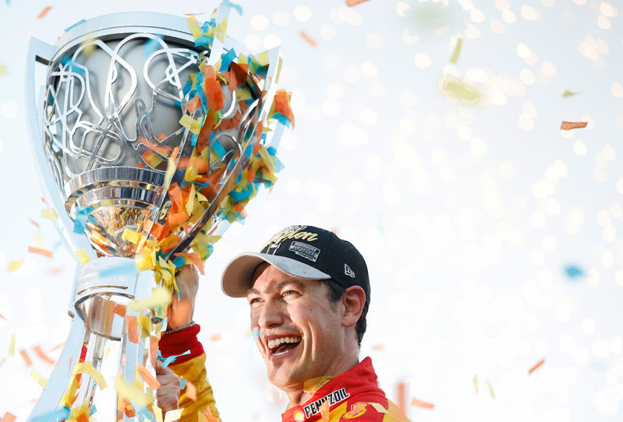 Joey Logano lifts the Bill France NASCAR Cup Series Championship trophy.