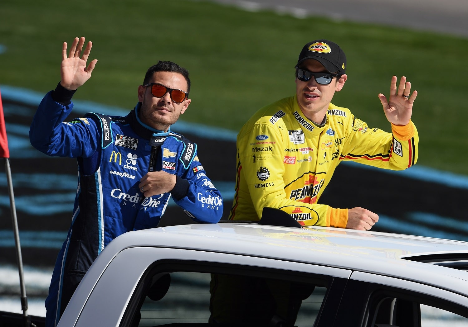 NASCAR Cup Series drivers Kyle Larson and Joey Logano wave to the fans during a parade lap before the Pennzoil 400 on Feb. 23, 2020, at Las Vegas Motor Speedway.