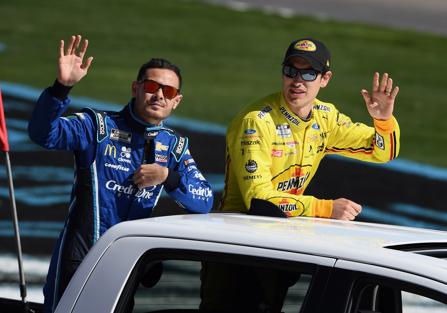 NASCAR Cup Series drivers Kyle Larson  and Joey Logano wave to the fans during a parade lap before the Pennzoil 400 on Feb. 23, 2020, at Las Vegas Motor Speedway. | John Cordes/Icon Sportswire via Getty Images