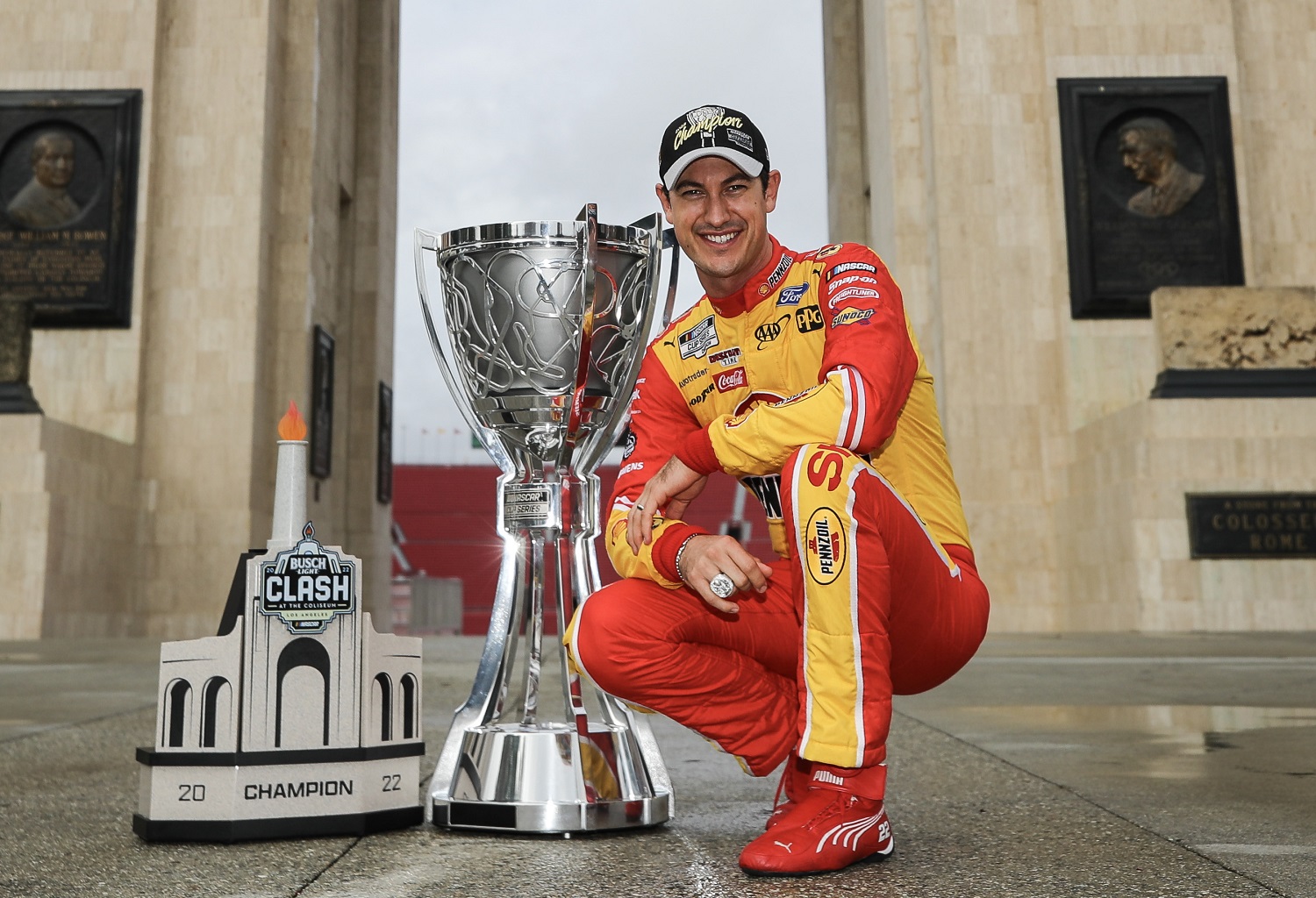 Joey Logano poses with the Bill France NASCAR Cup Series Championship trophy and his NASCAR Clash at the Coliseum trophy at LA Memorial Coliseum on Nov. 8, 2022.