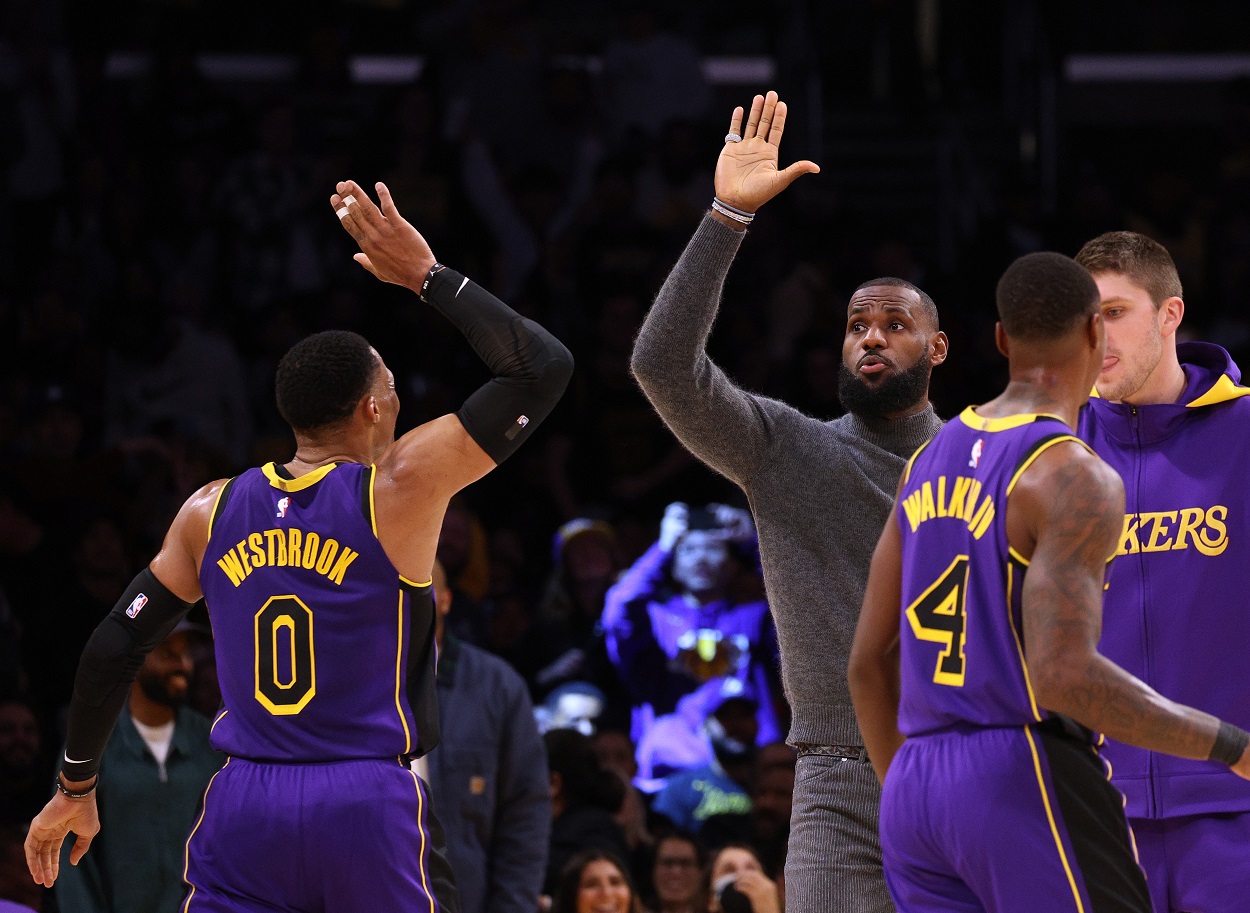 LeBron James high-fives Russell Westbrook during a Lakers-Pistons matchup in November 2022