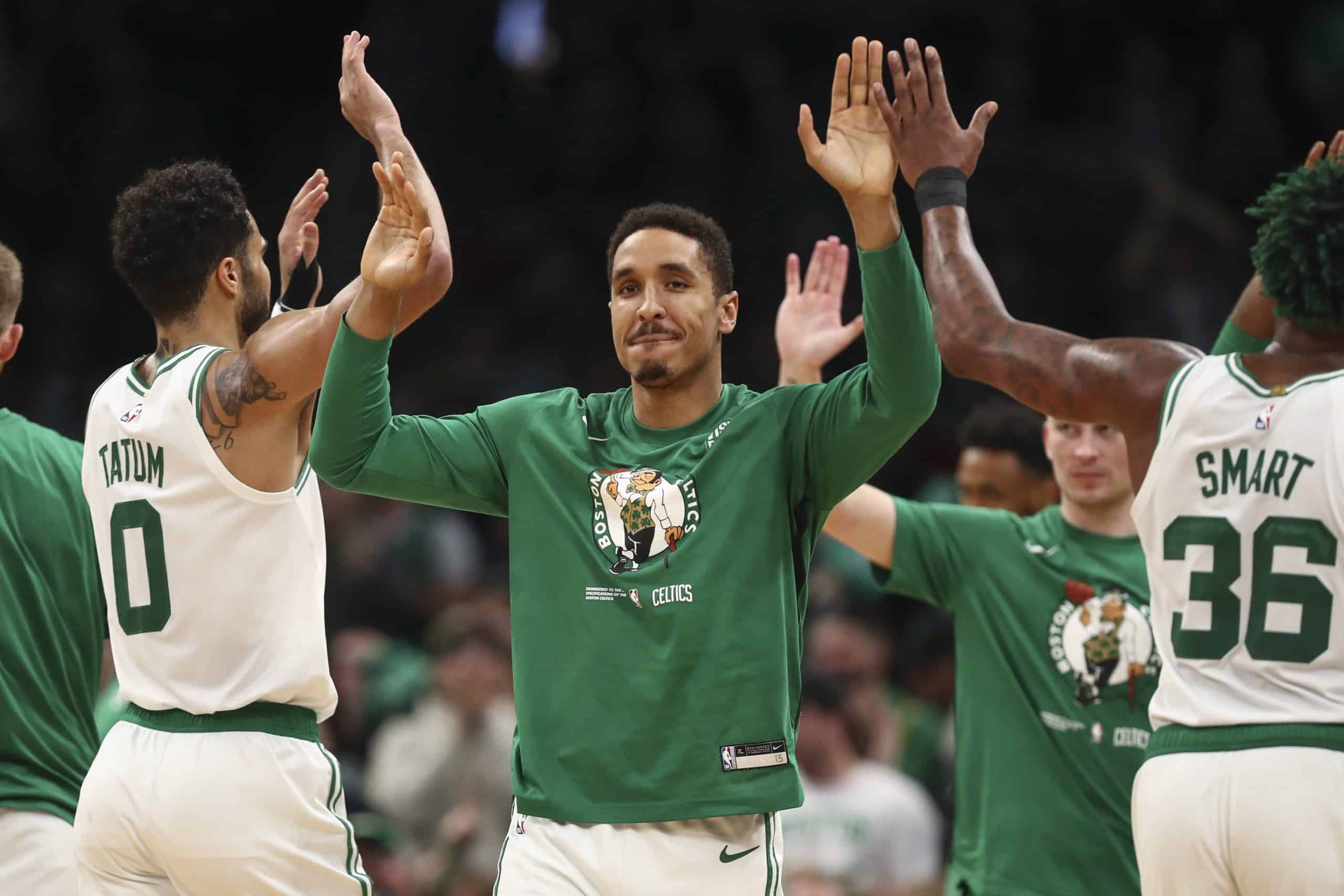 Malcolm Brogdon high fives Jayson Tatum.