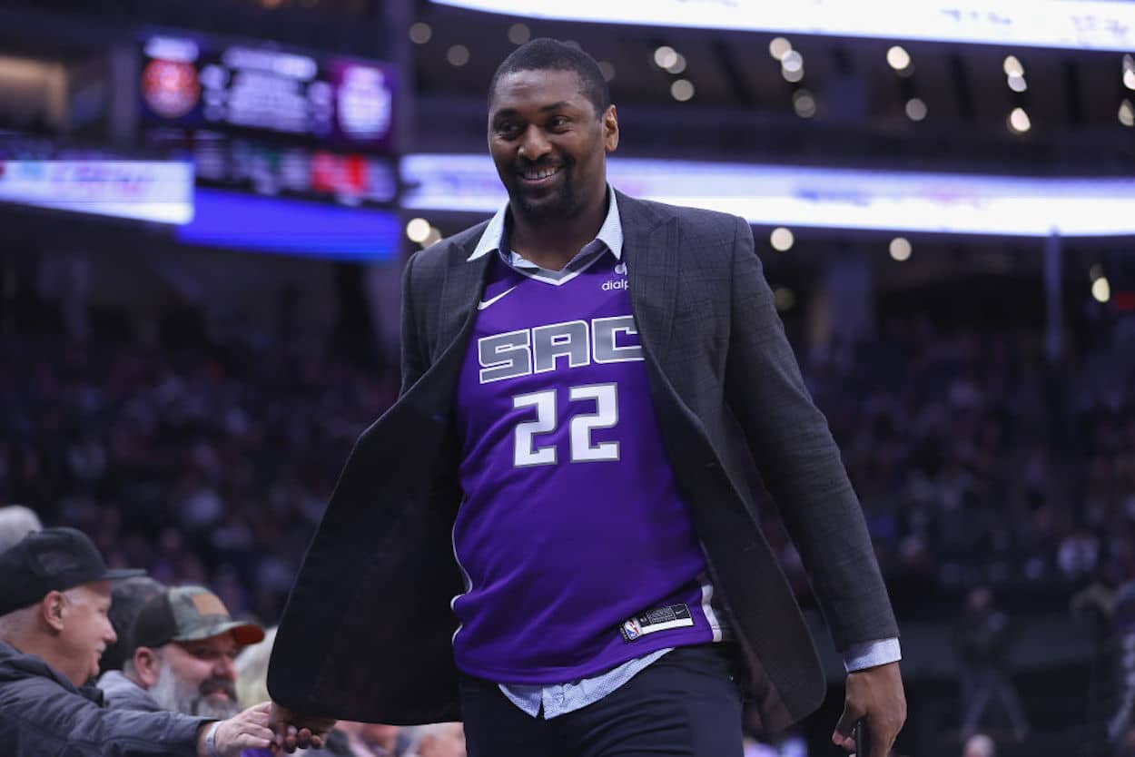 Metta World Peace walks the sidelines wearing a Sacramento Kings jersey.