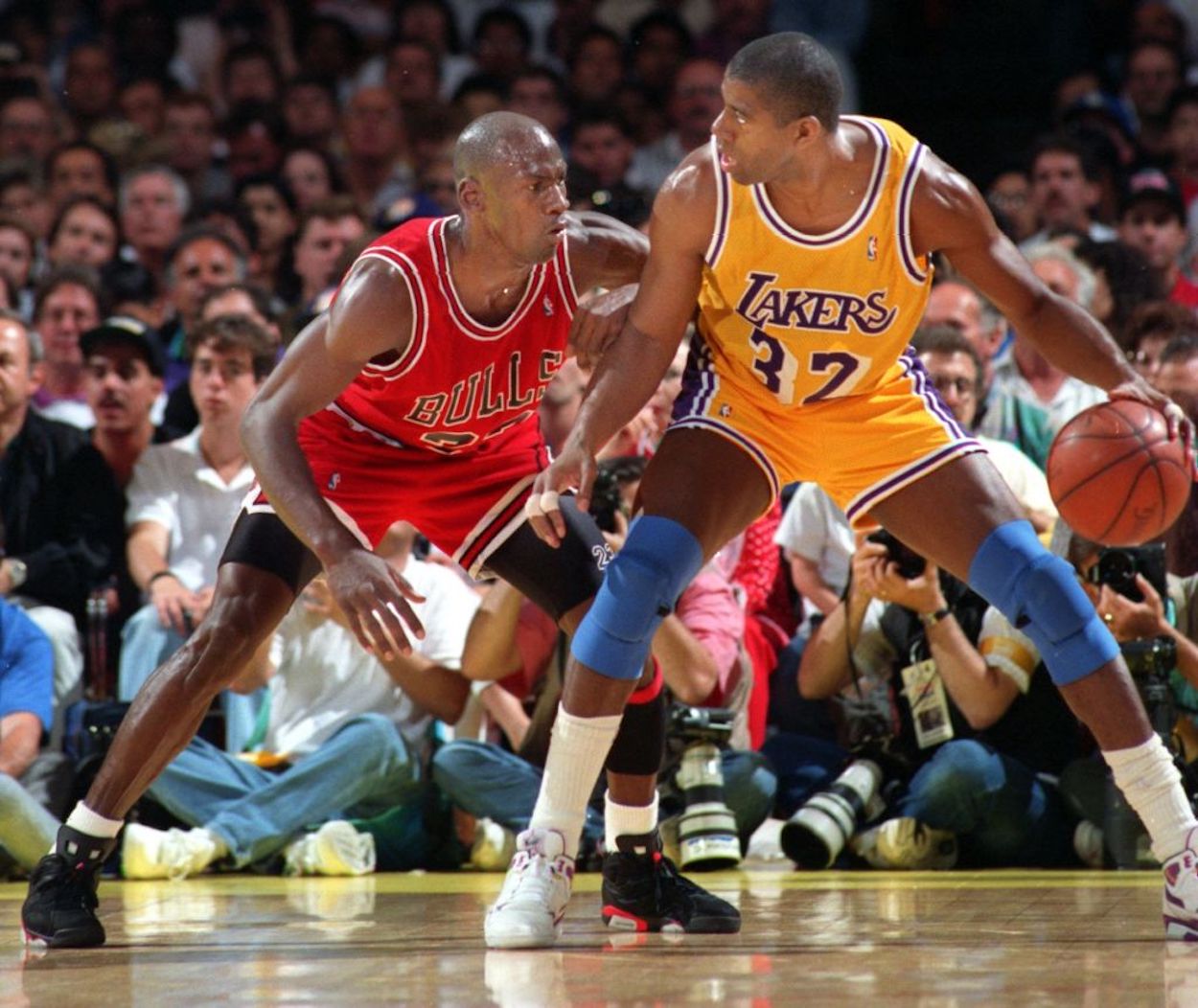 Magic Johnson (R) backs down Michael Jordan (L) during a Lakers-Bulls game.