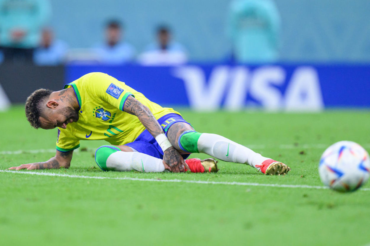 Brazilian star Neymar holds his injured ankle.