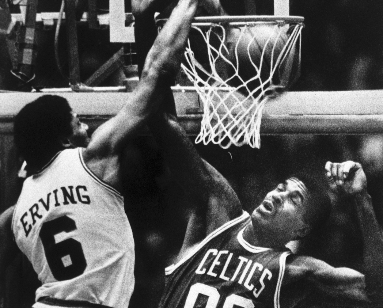 Julius Erving dunks the ball over Celtics' Robert Parish.