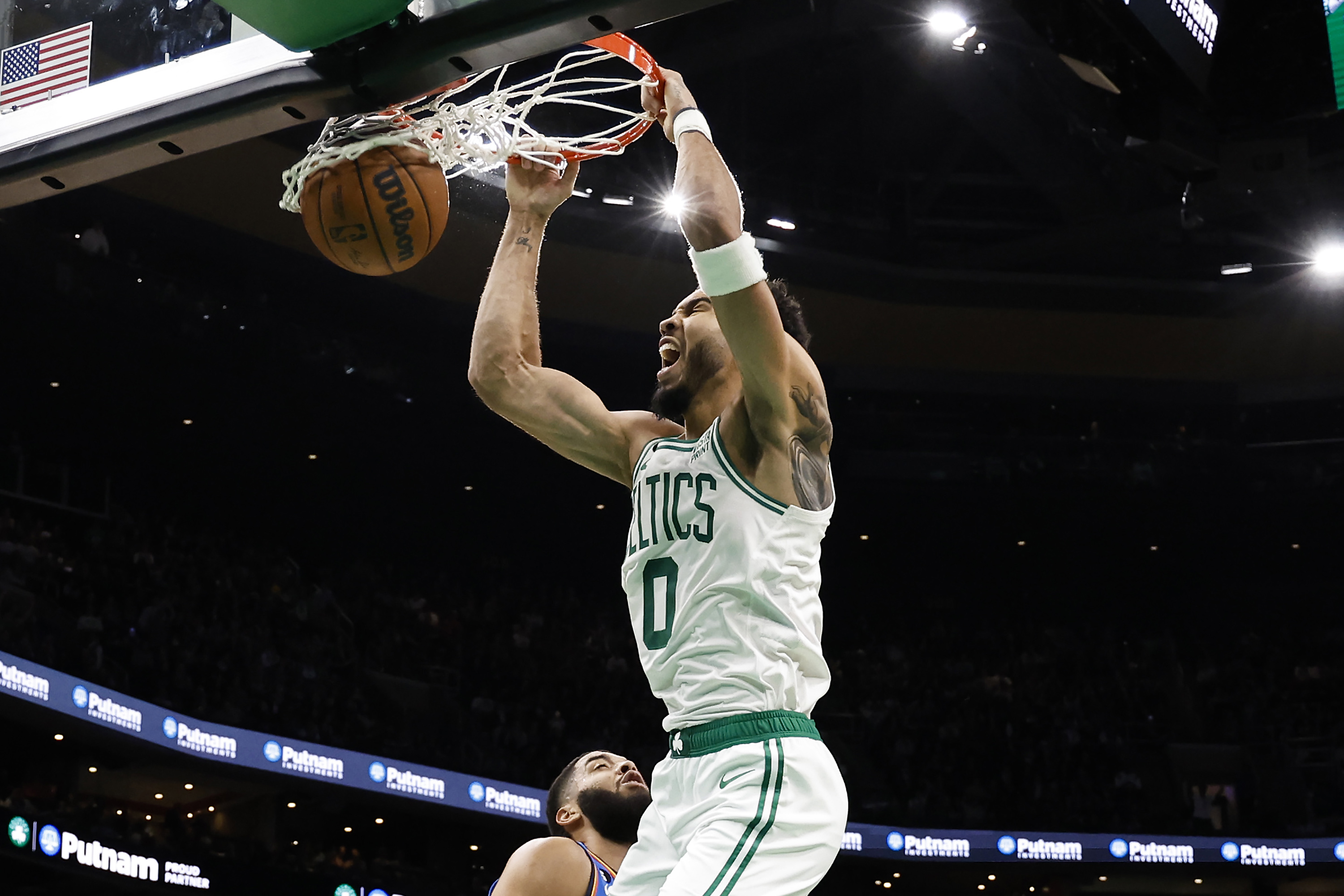 Jayson Tatum of the Boston Celtics dunks over Kenrich Williams of the Oklahoma City Thunder.