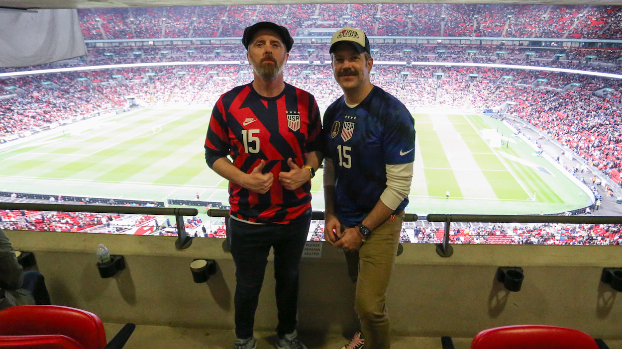 Actors Brendan Hunt and Jason Sudeikis from the show Ted Lasso pose for a picture during a game between England and USWNT at Wembley Stadium. The character Ted Lasso has some inspirational messages for USMNT players ahead of the 2022 World Cup.