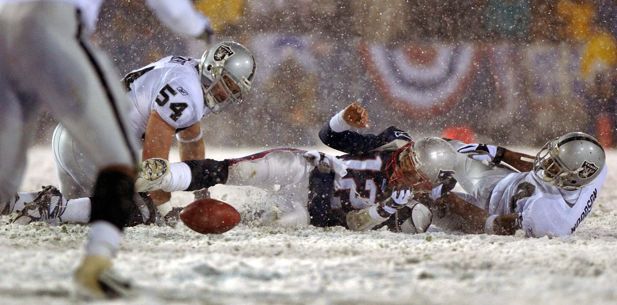 New England Patriots quarterback Tom Brady loses the ball after being hit by the Oakland Raiders Charles Woodson.