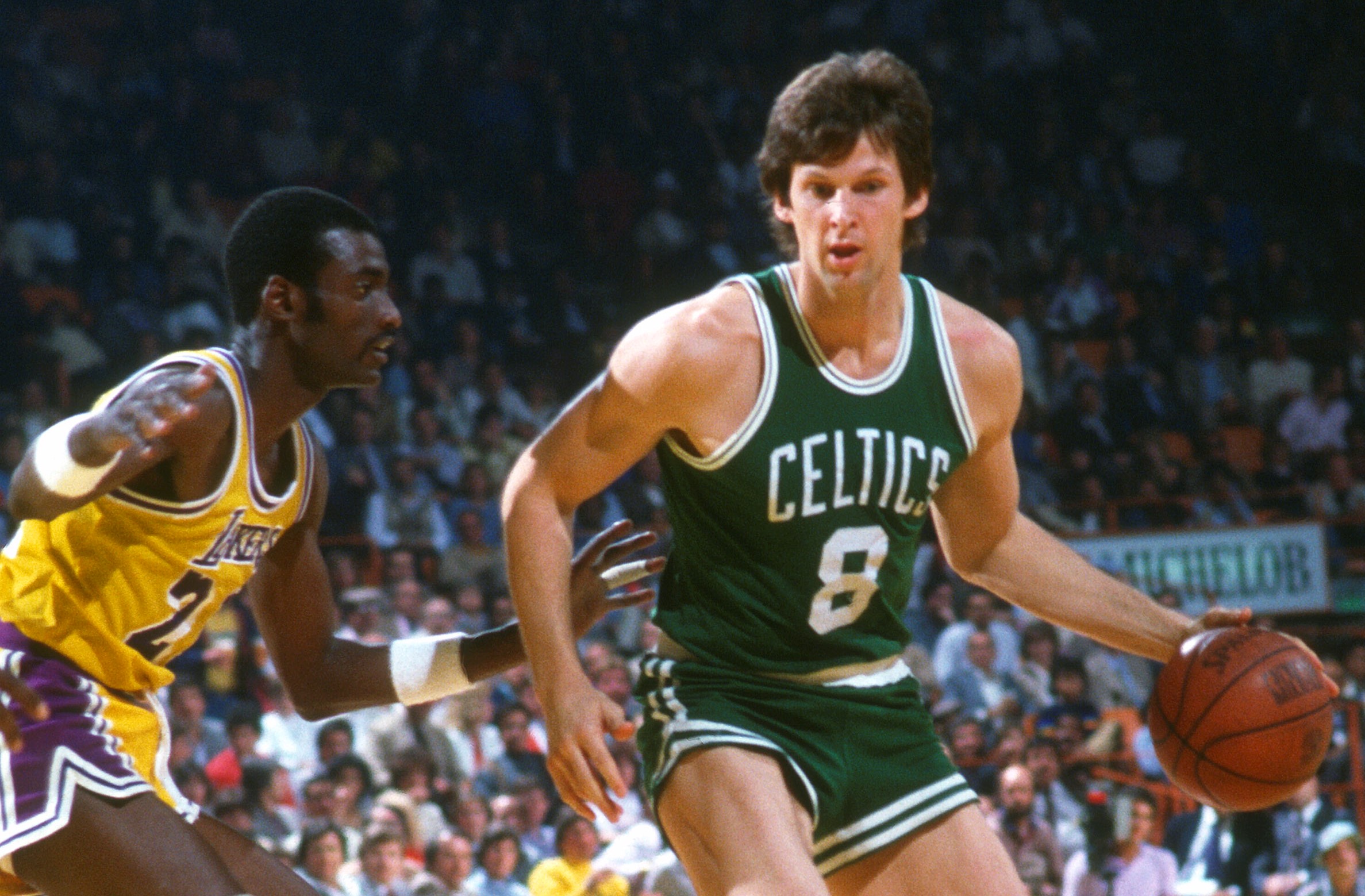 Scott Wedman of the Boston Celtics dribbles the ball while guarded by Michael Cooper of the Los Angeles Lakers.