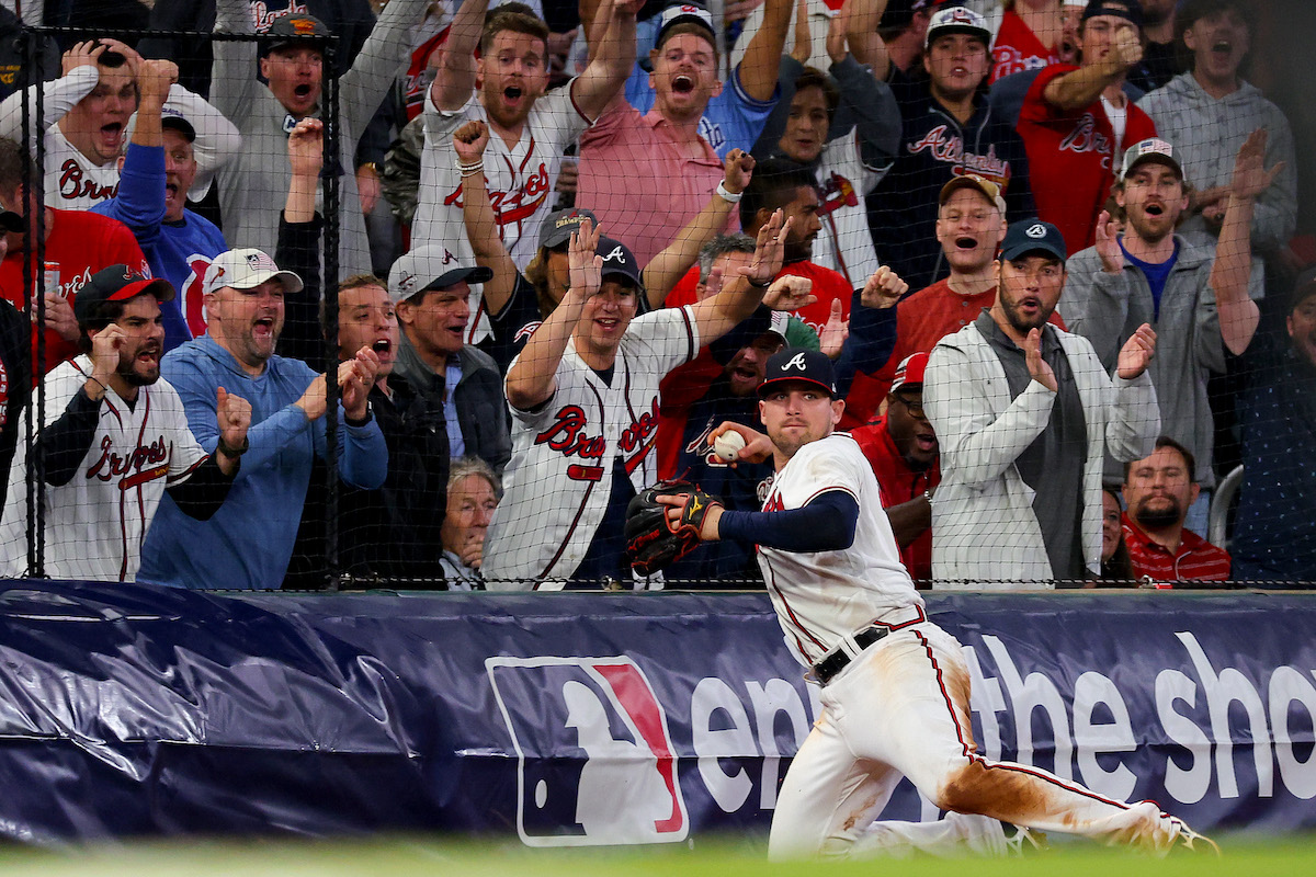 Fans cheer as Austin Riley of the Atlanta Braves throws the ball after making a catch