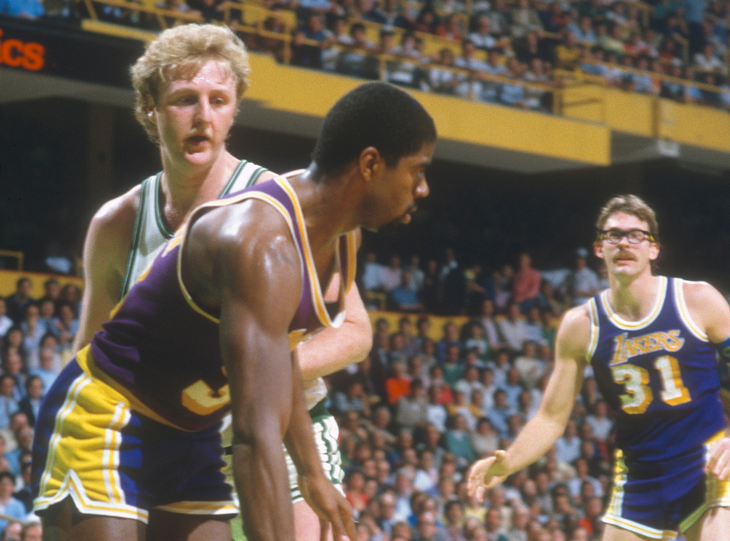 Magic Johnson of the Los Angeles Lakers dribbles the ball while closely guarded by Larry Bird of the Boston Celtics.