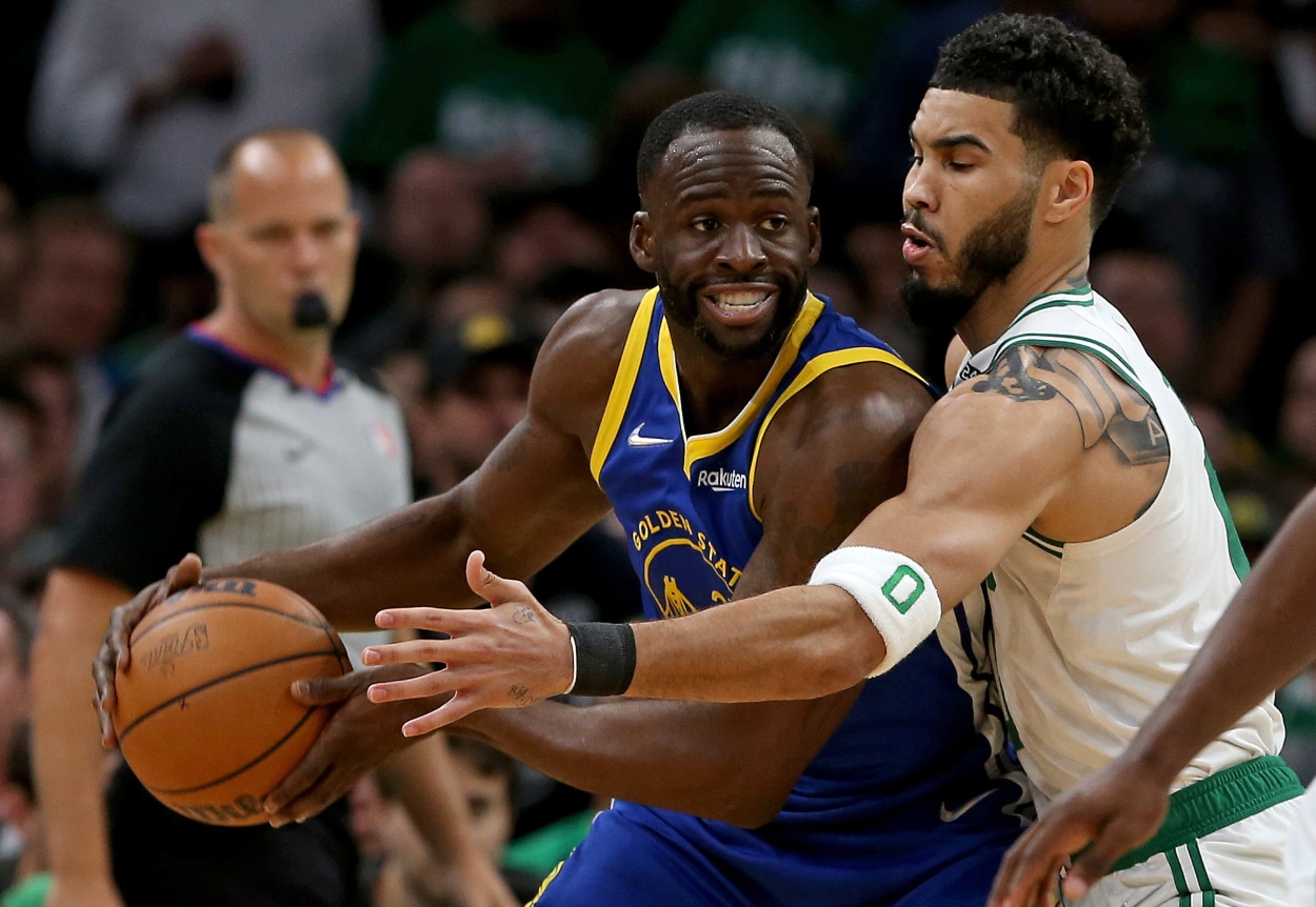 Jayson Tatum of the Boston Celtics guards Draymond Green of the Golden State Warriors.