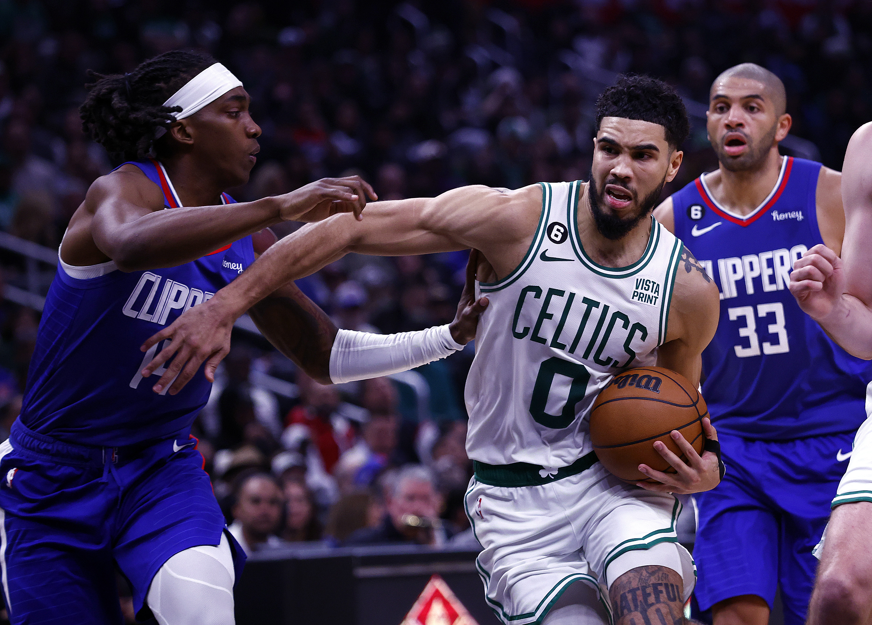 Jayson Tatum of the Boston Celtics controls the ball against Terance Mann of the LA Clippers.