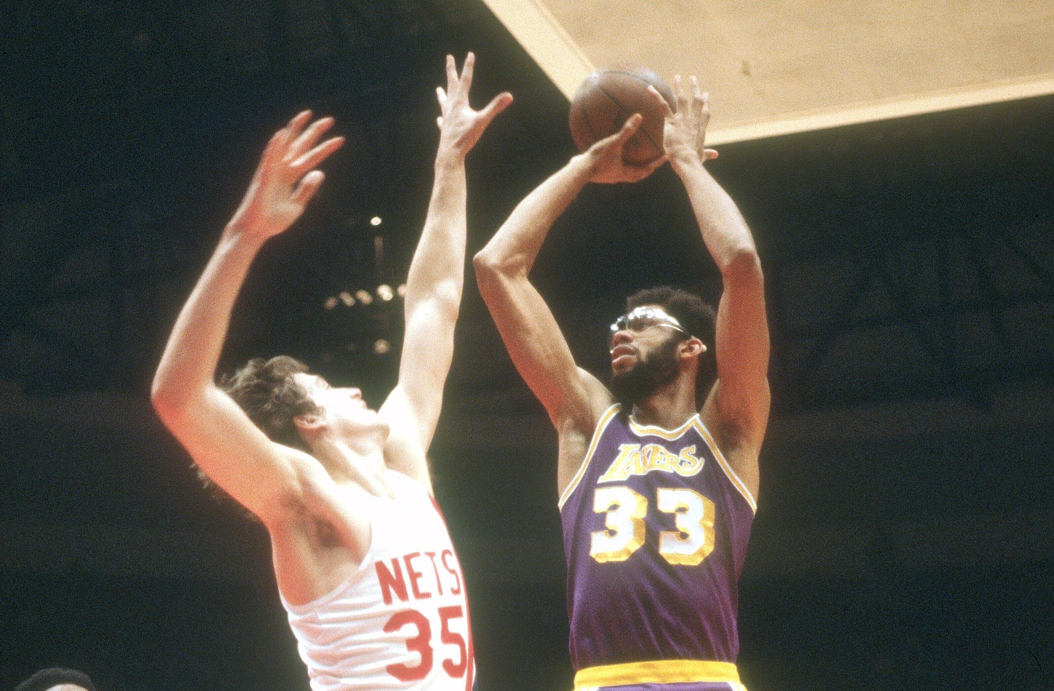 Kareem Abdul-Jabbar of the Los Angeles Lakers shoots over Kim Hughes of the New Jersey Nets.