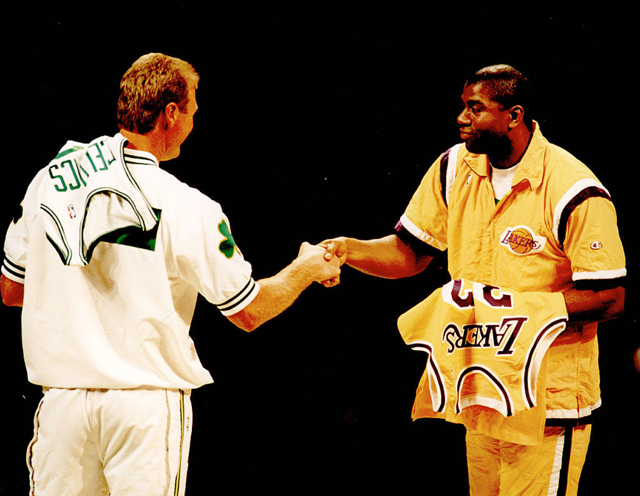 Larry Bird (L) and Magic Johnson (R) shake hands ahead of a 1993 game.