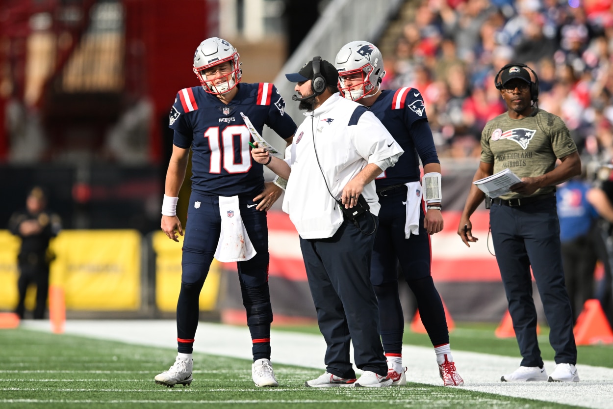 Mac Jones of the New England Patriots talks with senior football advisor Matt Patricia.