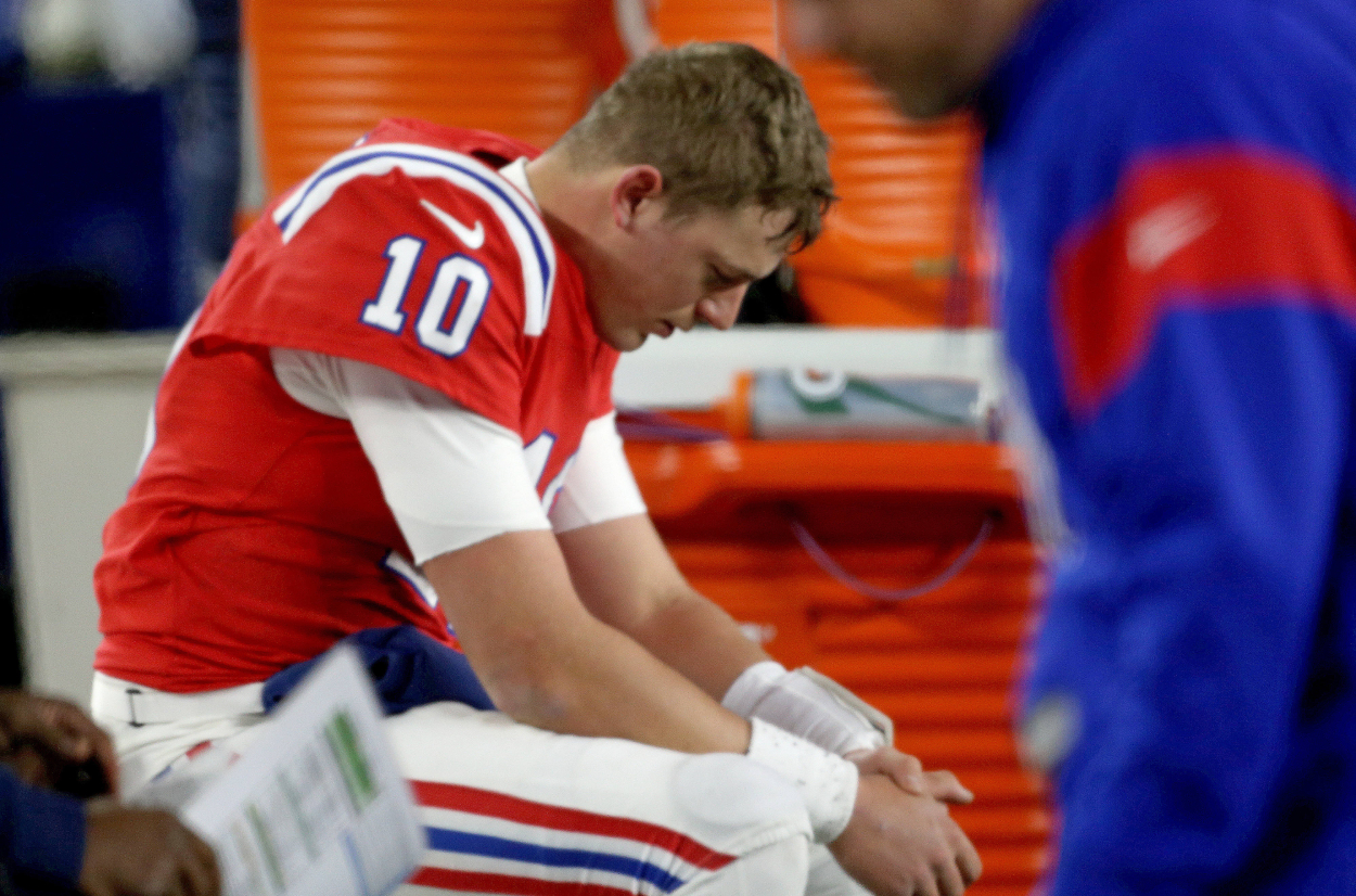 Mac Jones of the New England Patriots sits on the bench after losing 24-10 to the Buffalo Bills.