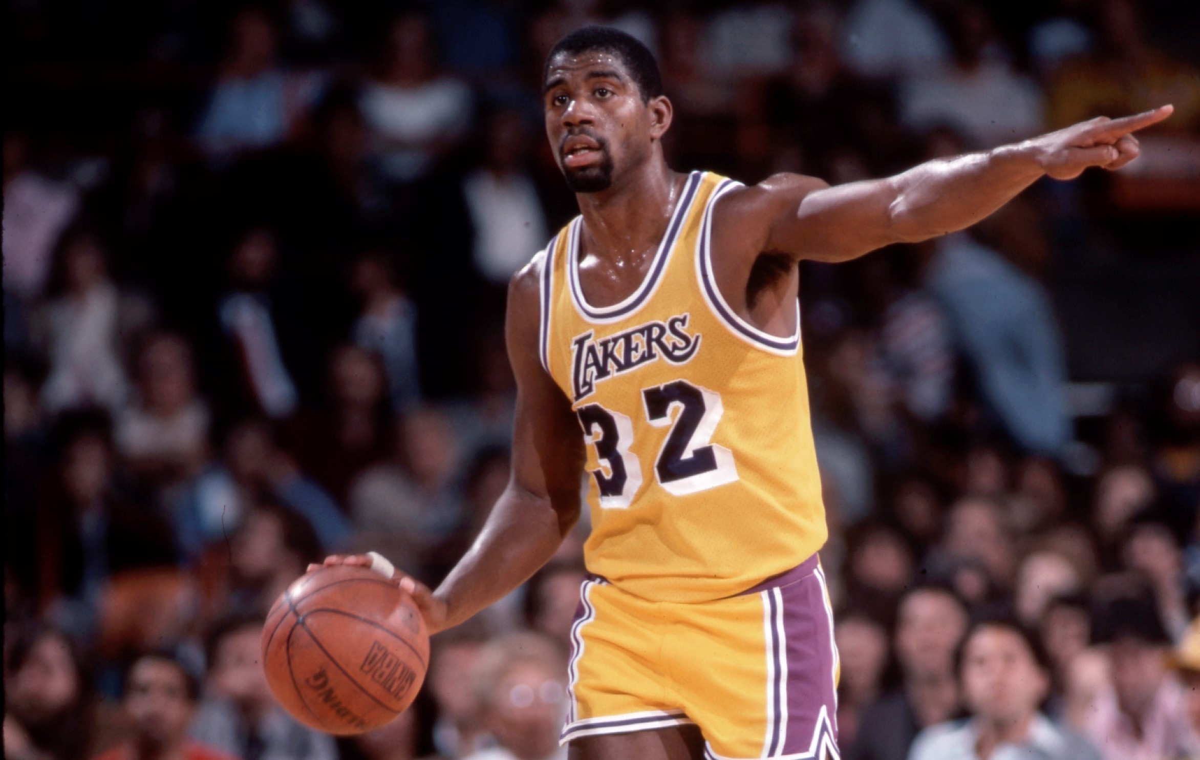 Magic Johnson of the Los Angeles Lakers dribbles up court.