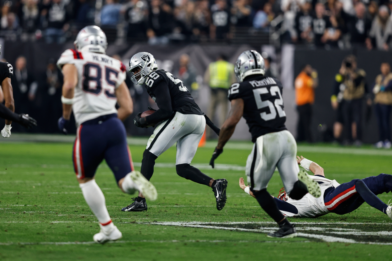 Chandler Jones of the Las Vegas Raiders intercepts a backward pass intended for Mac Jones of the New England Patriots and runs for a touchdown.