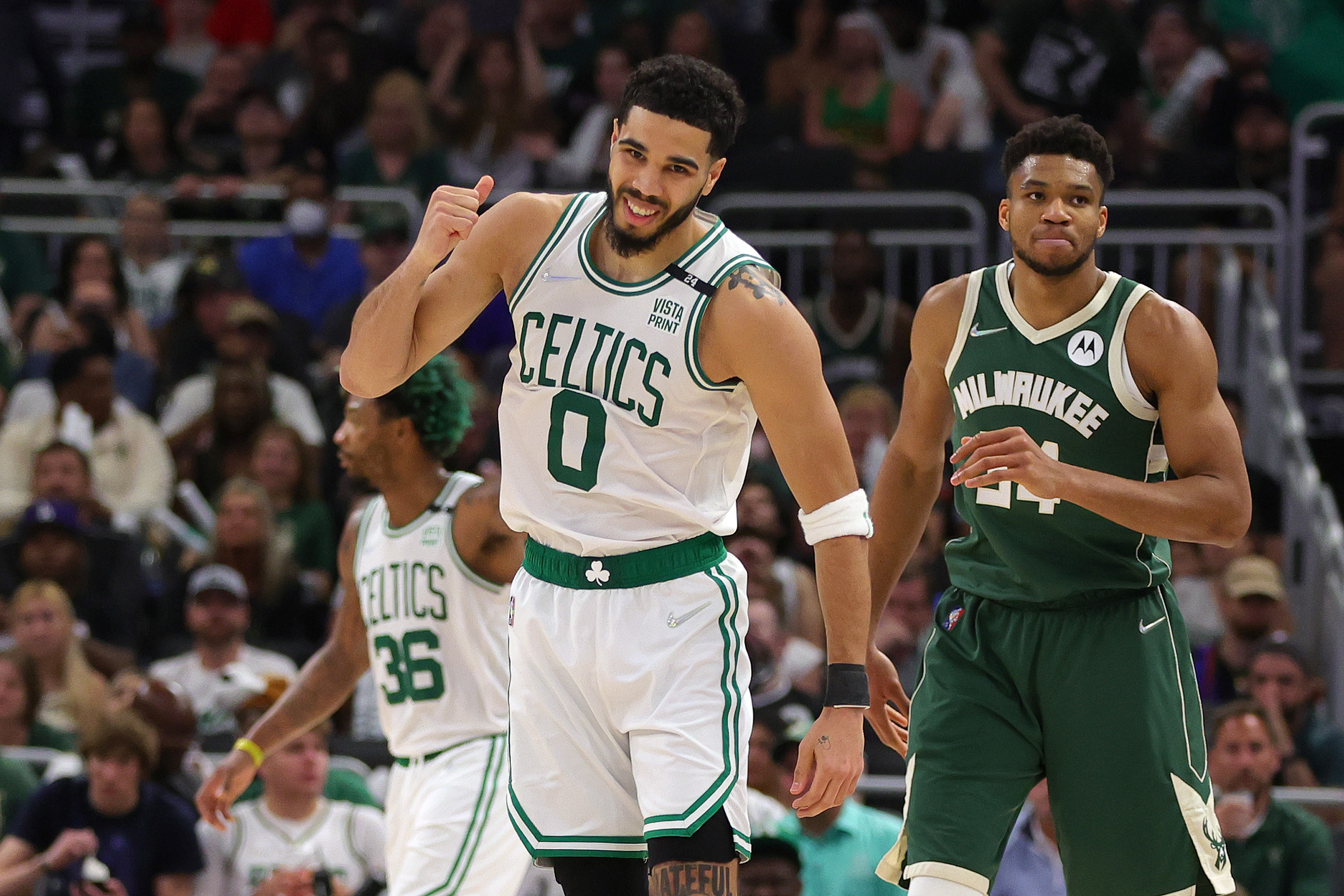 Jayson Tatum of the Boston Celtics celebrates a basket against Giannis Antetokounmpo of the Milwaukee Bucks.