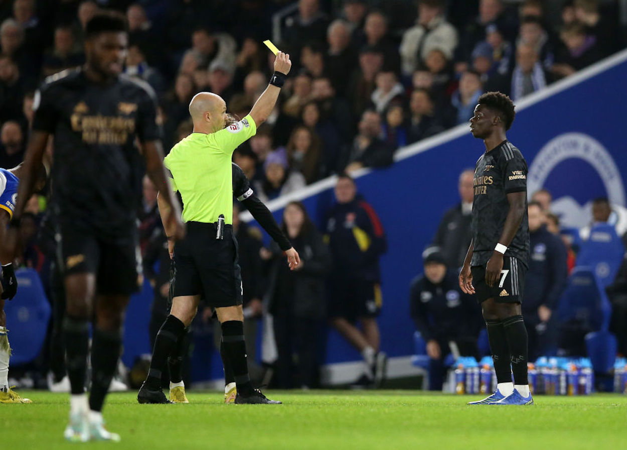 Arsenal forward Bukayo Saka receives a yellow card.