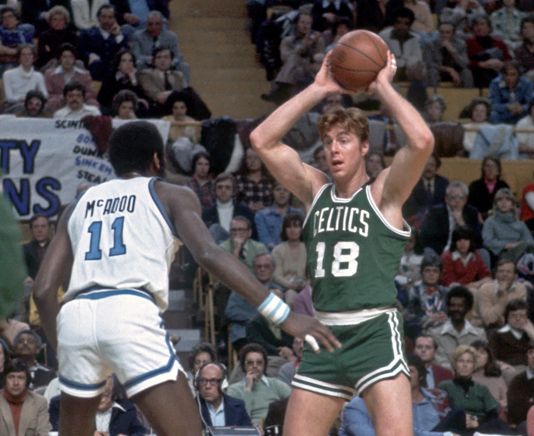 Center Dave Cowens of the Boston Celtics looks to pass as forward Bob McAdoo of the Buffalo Braves defends.