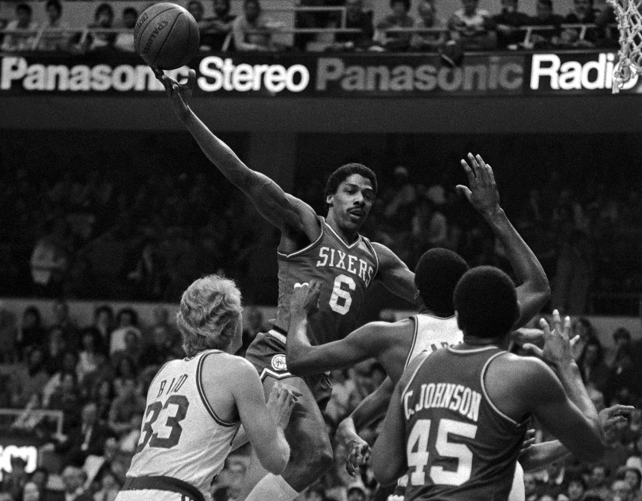 Philadelphia 76ers star Julius Erving goes high over Boston Celtics forward Larry Bird and Robert Parish.