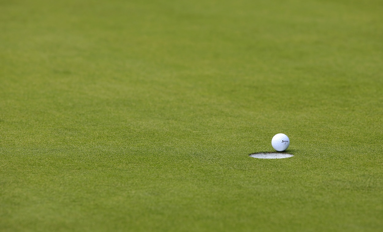 A golf ball sits on the lip.
