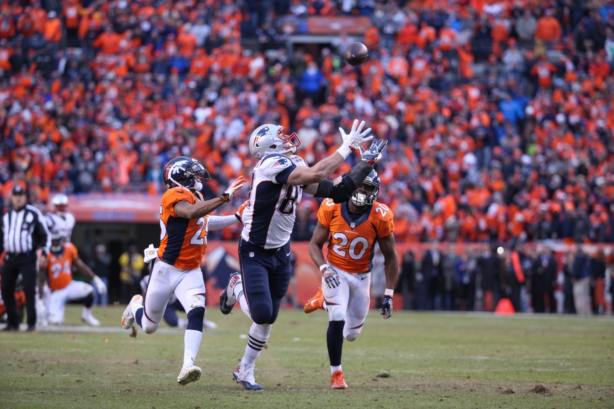 New England Patriots tight end Rob Gronkowski catches a pass over Denver Broncos cornerback Chris Harris (25) and Denver Broncos defensive back Josh Bush (20).