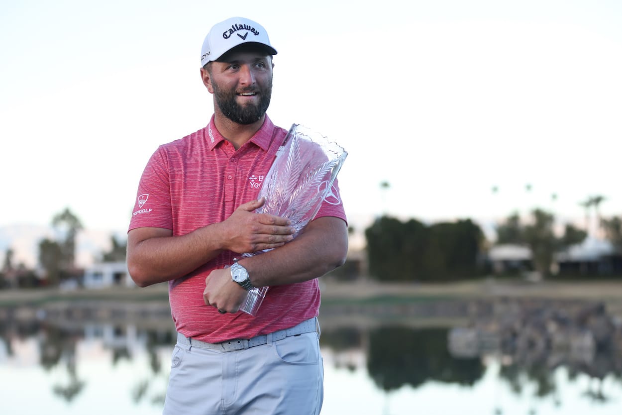 Jon Rahm celebrates with the American Express trophy.