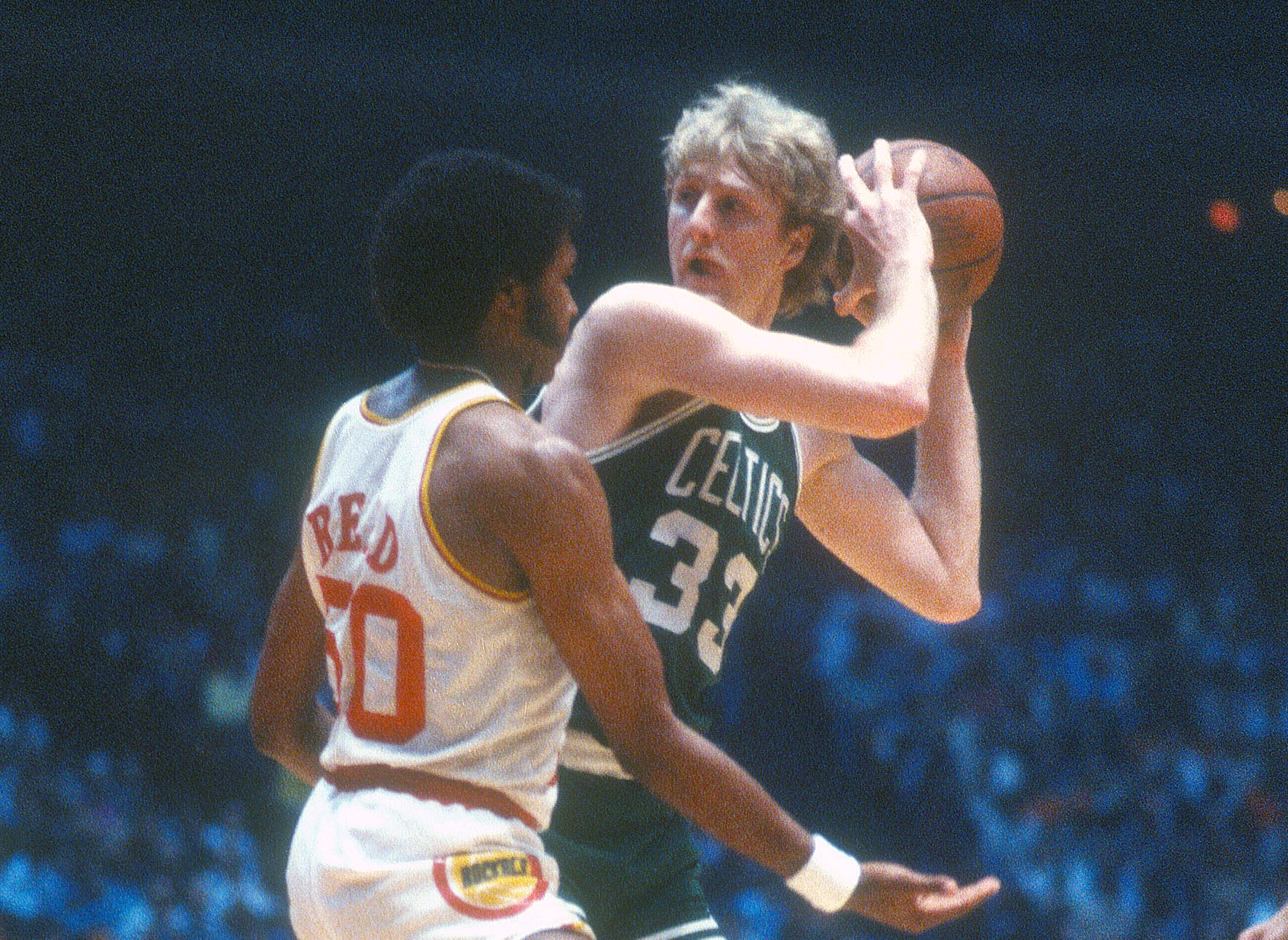 Larry Bird of the Boston Celtics looking to pass while being defended by Robert Reid of the Houston Rockets.