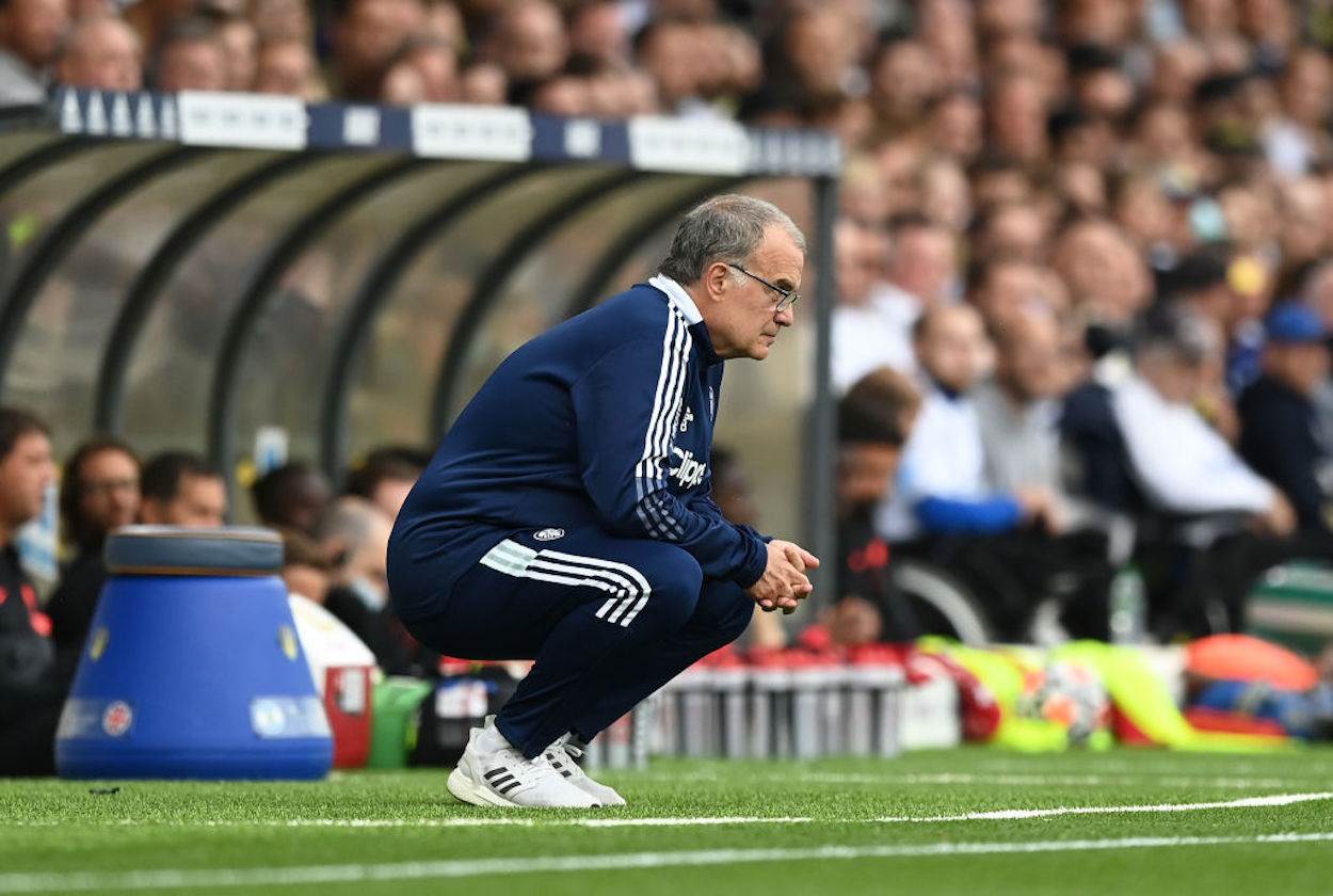 Marcelo Bielsa squats on the touchline during his time with Leeds.