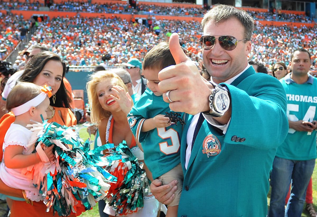 Miami Dolphins linebacker Zach Thomas gives a big thumbs up as he carries one of his children on the field prior to his induction into the Dolphins Ring of Honor in 2012
