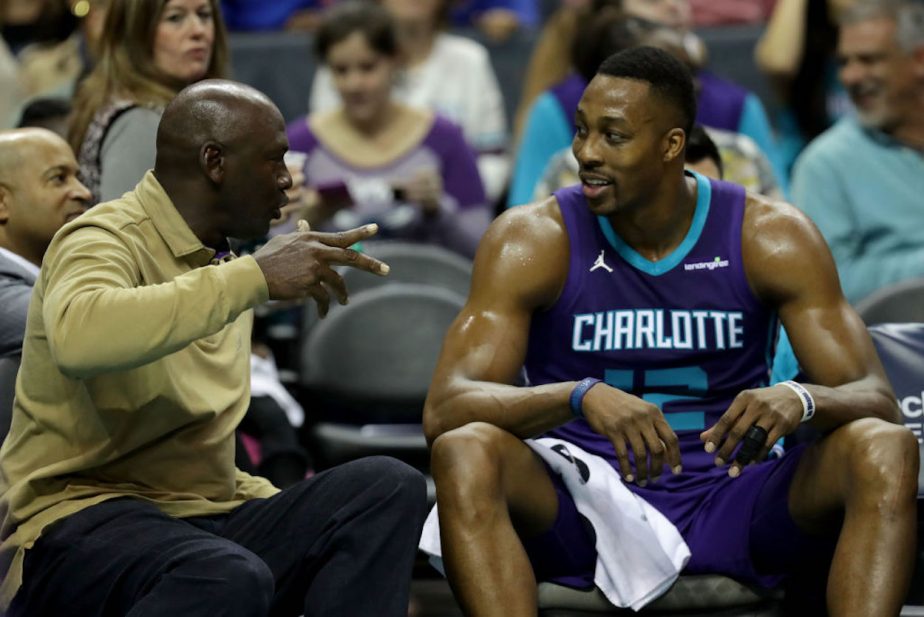 Michael Jordan talks to Dwight Howard during a Charlotte Hornets game.