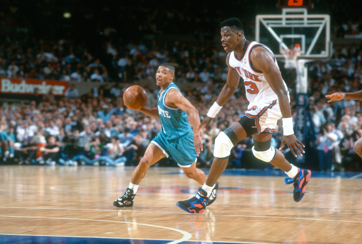 Muggsy Bogues of the Charlotte Hornets looks to pass the ball past Patrick Ewing.