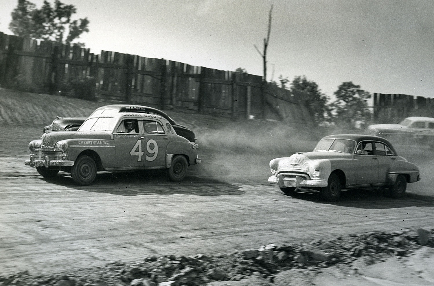 Glenn Dunnaway, left, battles with the field during the NASCAR race at Charlotte Speedway in June 1950.